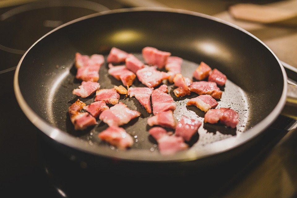 Pieces of bacon in a frying pan.