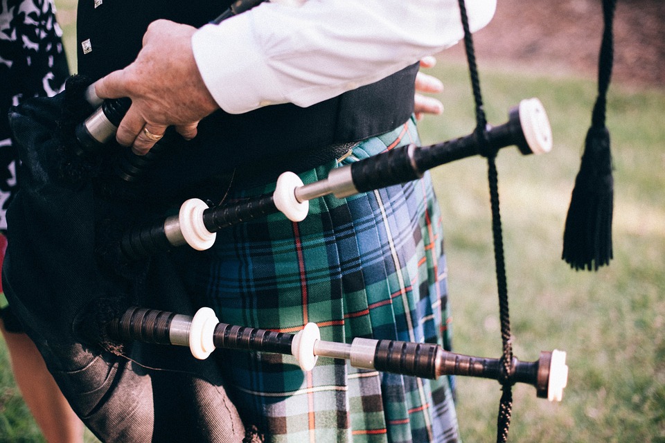 A man with bagpipes and a kilt.