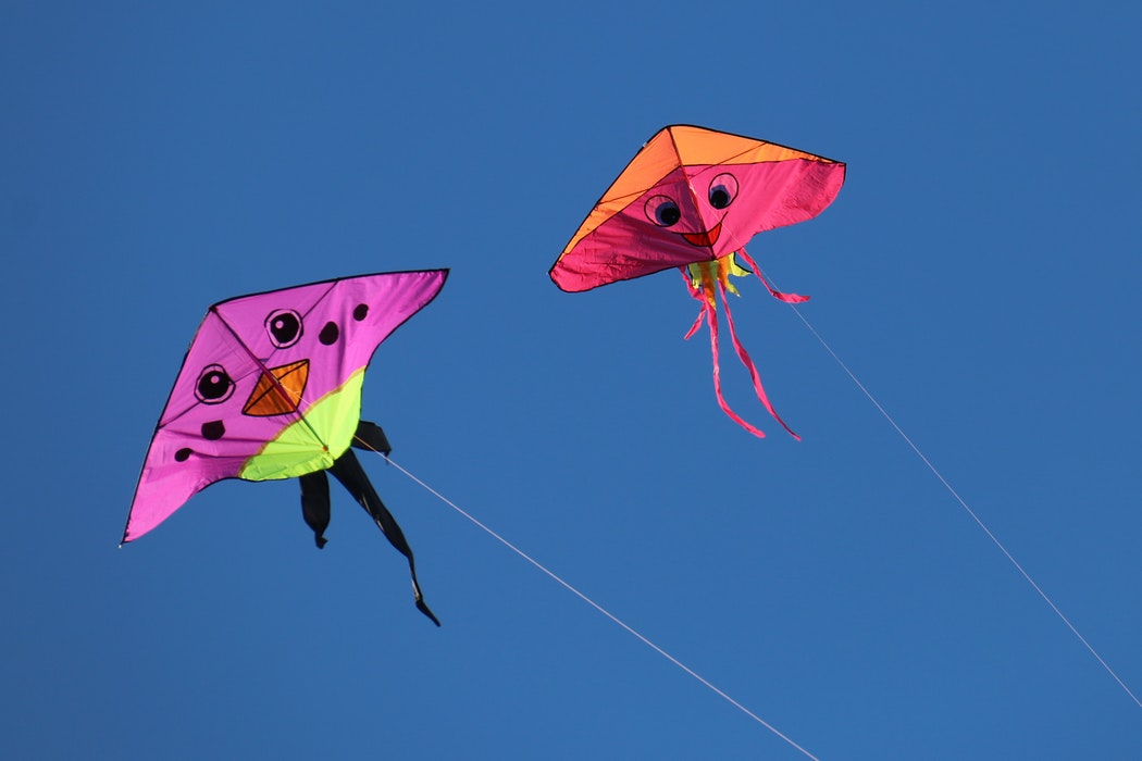 two kites flying in the sky.