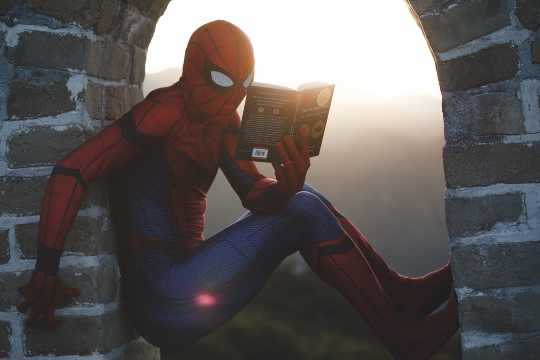 Spiderman reading a book.