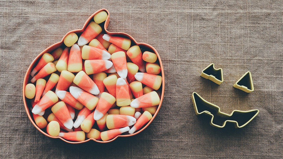 Candy corn in a pumpkin shaped bowl.